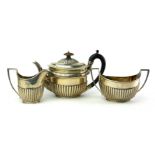 A VICTORIAN SILVER THREE PIECE TEA SERVICE Comprising a teapot with carved wooden finial and