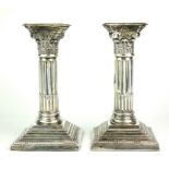A FINE PAIR OF LATE EDWARDIAN HALLMARKED SILVER CLASSICAL CANDLESTICKS Each on stepped square