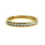 A YELLOW METAL AND DIAMOND 'OVERSIZE' ETERNITY RING Having a single row of round cut diamonds. (