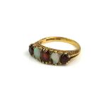 AN EARLY 20TH CENTURY 18CT GOLD RING SET WITH OPALS FLANKED BY GARNETS (size P). Condition: small