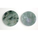 TWO CHINESE JADE ROUNDELS Having fine carving of figures in exotic landscapes. (approx 5.5cm)