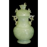 A CHINESE CARVED JADE VASE AND COVER Having twin form handles and relief carved scrolled decoration.