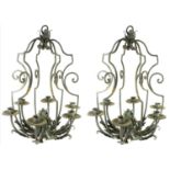 A PAIR OF WROUGHT IRON SIX BRANCH CHANDELIERS The scroll arms applied with leaves. (56cm x 43cm)