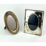 AN EARLY 20TH CENTURY SILVER OVAL PHOTOGRAPH FRAME With engine turned decoration and oak easel back,