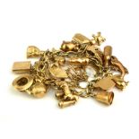 A VINTAGE 9CT GOLD CHARM BRACELET Having twenty four charms of various designs including a