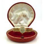 OMEGA, A VINTAGE 9CT GOLD LADIES' WRISTWATCH The silver tone dial with integral bracelet, in a