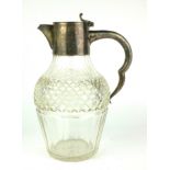AN EARLY 20TH CENTURY SILVER AND CUT GLASS CLARET JUG Having a silver collar and handle with hobnail