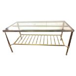 IN THE MANNER OF MAISON JANSEN, A BRASS COFFEE TABLE With inset glass top above a magazine rack. (