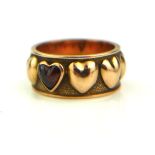 A VINTAGE YELLOW METAL AND GARNET WEDDING BAND Set with a single cabochon cut garnet stone flanked