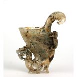 A CHINESE ROCK CRYSTAL CUP Scrolled helmet form with carved decoration and dragon form support to