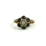 A MID 20TH CENTURY 9CT GOLD RING SET WITH FLORAL FORM DIAMOND AND DIAMONDS AND SAPPHIRES (size P).
