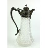 AN EDWARDIAN SILVER AND CUT GLASS CLARET JUG The single handle with embossed decoration and