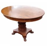 A CONTINENTAL MAHOGANY OVAL CENTRE TABLE Raised on a tulip and faceted column standing on platform