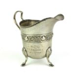 AN EARLY 20TH CENTURY IRISH SILVER CREAM JUG Classical helmet form with celtic knot band and