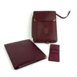 CARTIER, A COLLECTION OF VINTAGE BURGUNDY LEATHER ITEMS Comprising a notepad and paper satchel