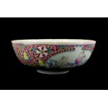 A CHINESE PORCELAIN BOWL Decorated with traditional figures within two panels on puce ground,