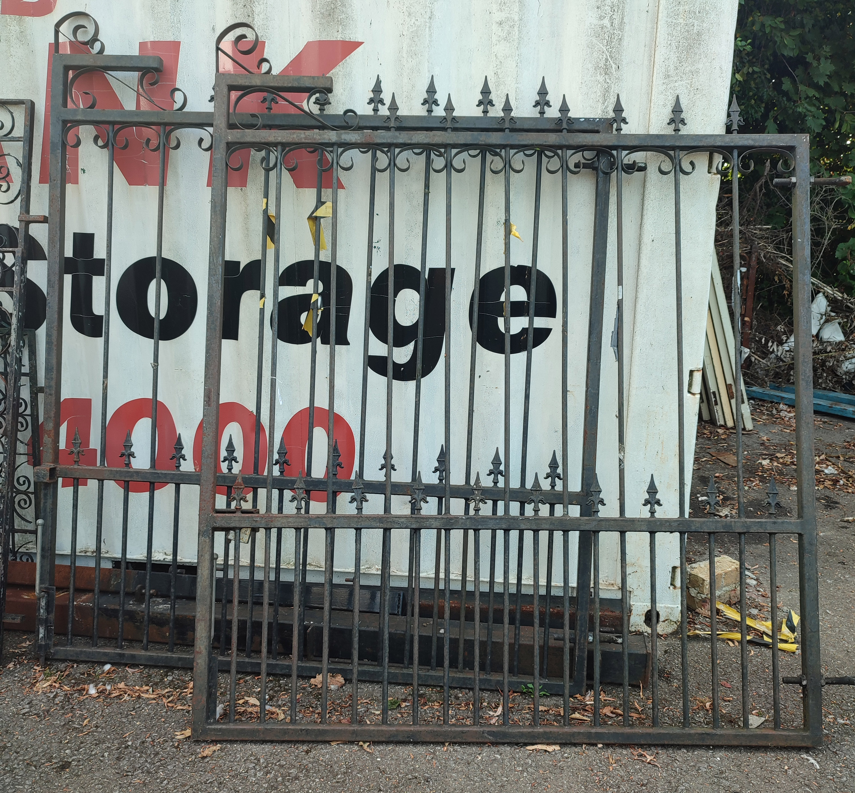 A PAIR OF LARGE VICTORIAN WROUGHT IRON DRIVEWAY GATES With fleur-de-lis and scroll arches with post.