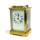A VINTAGE GILT BRASS CARRIAGE CLOCK Having four bevelled glass panels and striking mechanism, dial