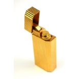 MUST DE CARTIER, A VINTAGE 18CT GOLD PLATED CIGARETTE LIGHTER Having a chamfered edge and reeded