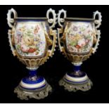 A PAIR OF 19TH CENTURY FRENCH PORCELAIN AND GILT METAL VASES Twin handles with hand painted