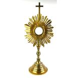 A 19TH CENTURY GILT METAL MONSTRANCE Having a crucifix finial, the central glazed compartment set