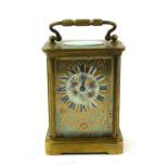 AN EARLY 20TH CENTURY FRENCH GILT BRASS AND ENAMEL CARRIAGE CLOCK Having a single carry handle and