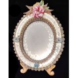 A LATE 19TH CENTURY OVAL VENETIAN MIRROR Crested with flowers above an etched glass plate. (29cm x