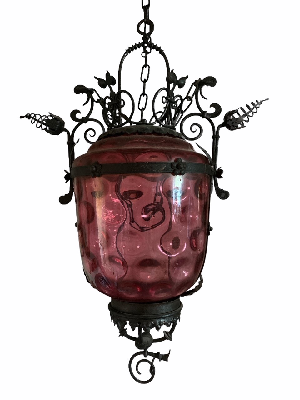 A VICTORIAN SCROLLING WROUGHT IRON AND CRANBERRY GLASS HALL LANTERN. (drop 67cm x w 48cm)