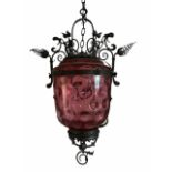 A VICTORIAN SCROLLING WROUGHT IRON AND CRANBERRY GLASS HALL LANTERN. (drop 67cm x w 48cm)