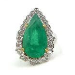 A 18CT WHITE GOLD, EMERALD AND DIAMOND RING The pear shaped emerald surrounded by diamonds. (size