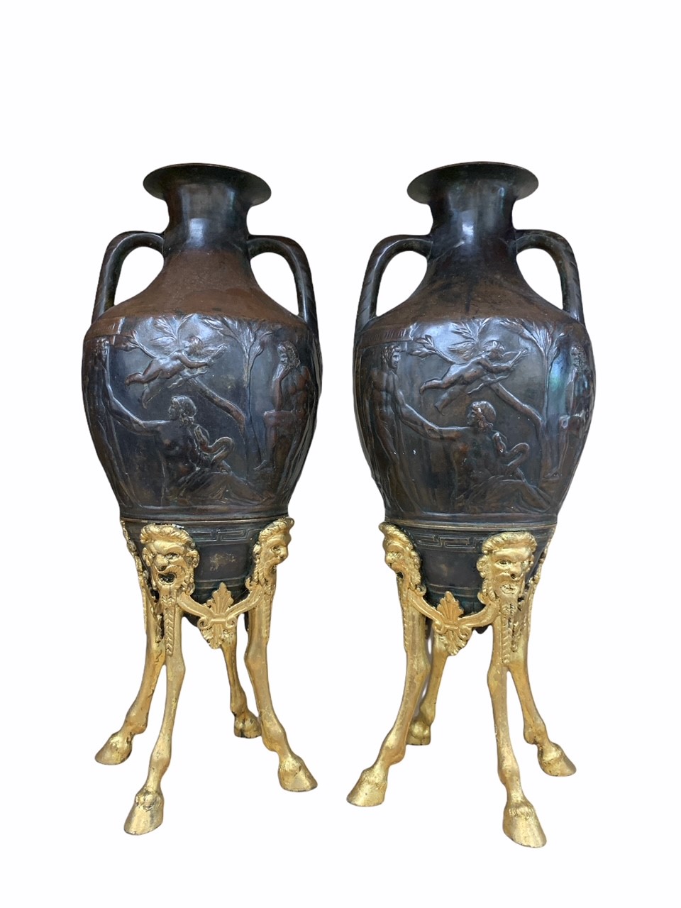 A PAIR OF 19TH CENTURY BRONZE AND PARCEL GILT URNS Cast with Neoclassical scenes to body, raised