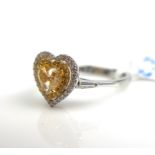 AN 18CT WHITE GOLD & YELLOW DIAMOND HEART SHAPED RING The central yellow diamond surrounded by