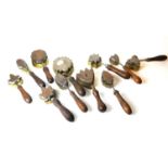 A COLLECTION OF TEN VICTORIAN FLOWER MAKING IRON MOULDS Applied with turned wooden handles.