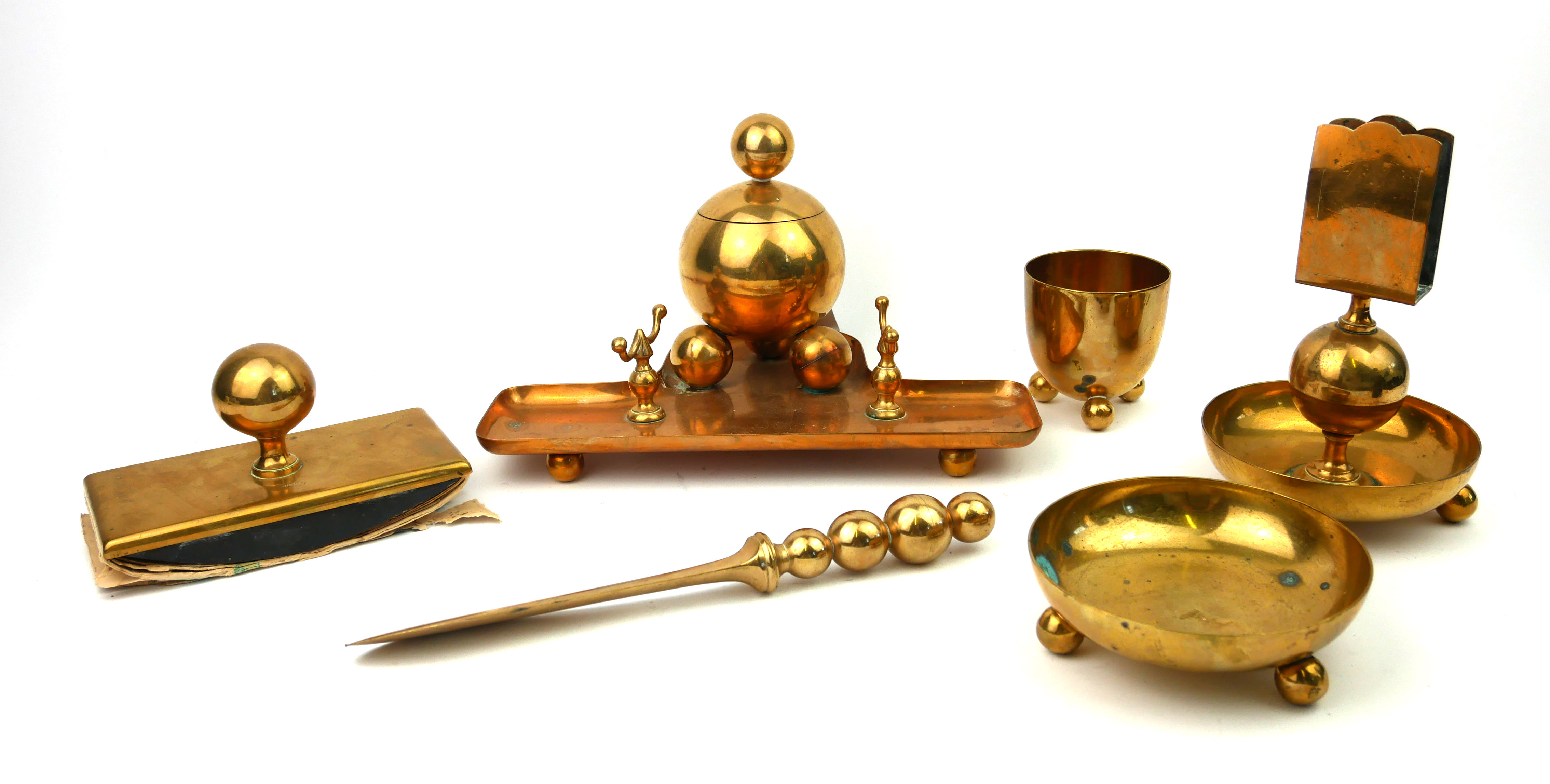 AN ART DECO BRASS DESK SET Comprising an inkstand with spherical inkwell, matching letter knife,