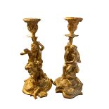 A PAIR OF GILT BRONZE FIGURAL CLASSICAL CANDLESTICKS With figures riding seahorses and dolphins,