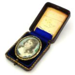 A 19TH CENTURY YELLOW METAL AND IVORY OVAL PORTRAIT MINIATURE Depicting a young maiden wearing