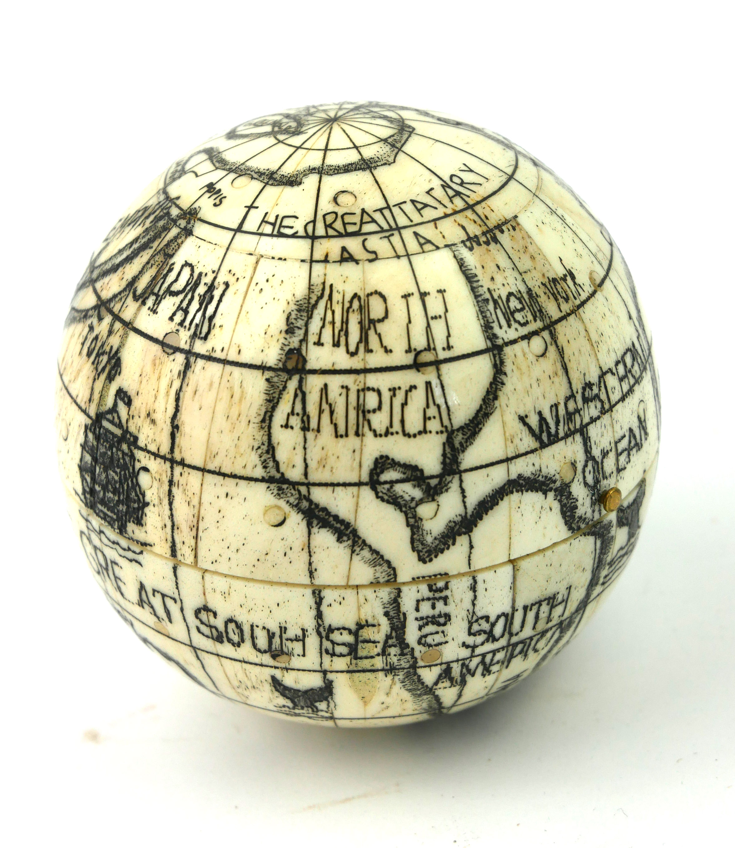 A 20TH CENTURY CARVED BONE SPHERICAL POCKET GLOBE COMPASS With black ink decoration and a glazed