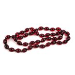 A CHERRY AMBER DESIGN NECKLACE Having a single row of oval form beads. (approx 42cm)