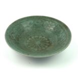 A CHINESE CELADON GLAZED BOWL Having embossed scrolled decoration, with five stilt kiln marks to