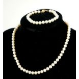 A 14CT GOLD AND PEARL NECKLACE AND BRACELET SET Having a single row of pearls with spherical 14ct