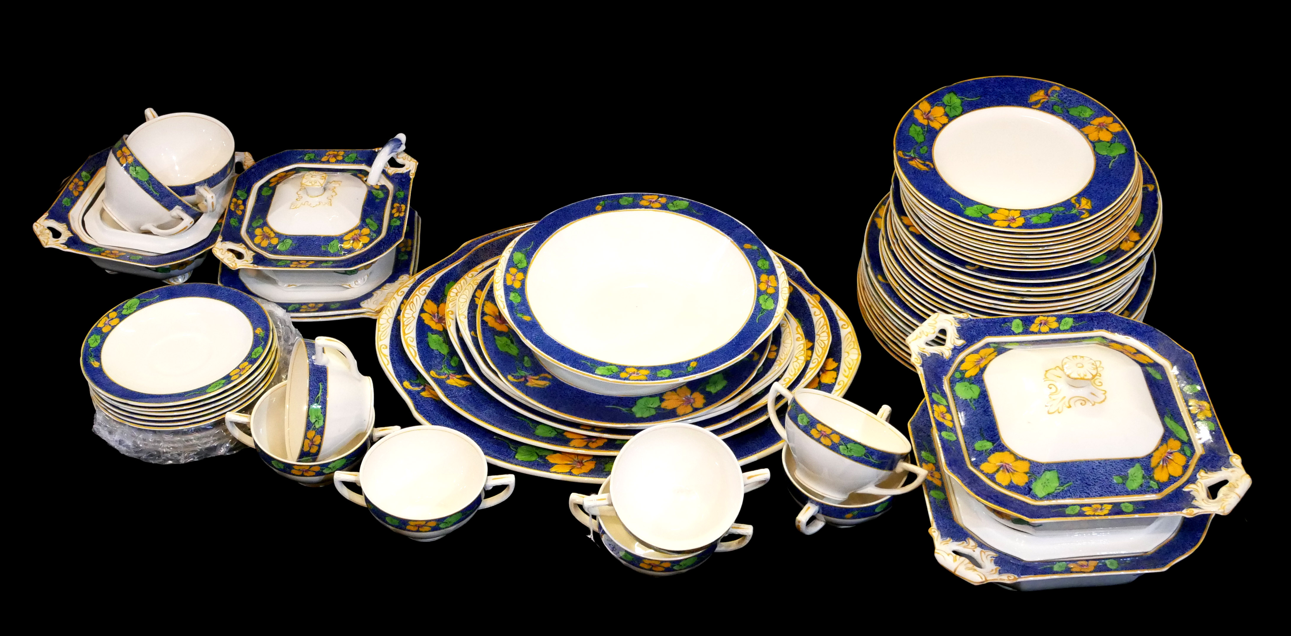 AN ART DECO ENGLISH POTTERY DINNER SERVICE Geometric form with wide blue border and floral