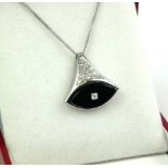 AN 18CT WHITE GOLD, DIAMOND AND BLACK ONYX PENDANT NECKLACE The triangular form pendant set with