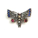 A VICTORIAN YELLOW METAL, DIAMOND, SAPPHIRE AND RUBY BUTTERFLY BROOCH The centre set with