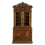 AN EARLY 20TH CENTURY OAK FLEMISH GLAZED BOOKCASE, EXTENSIVELY CARVED WITH GAME AND STAG'S HEAD