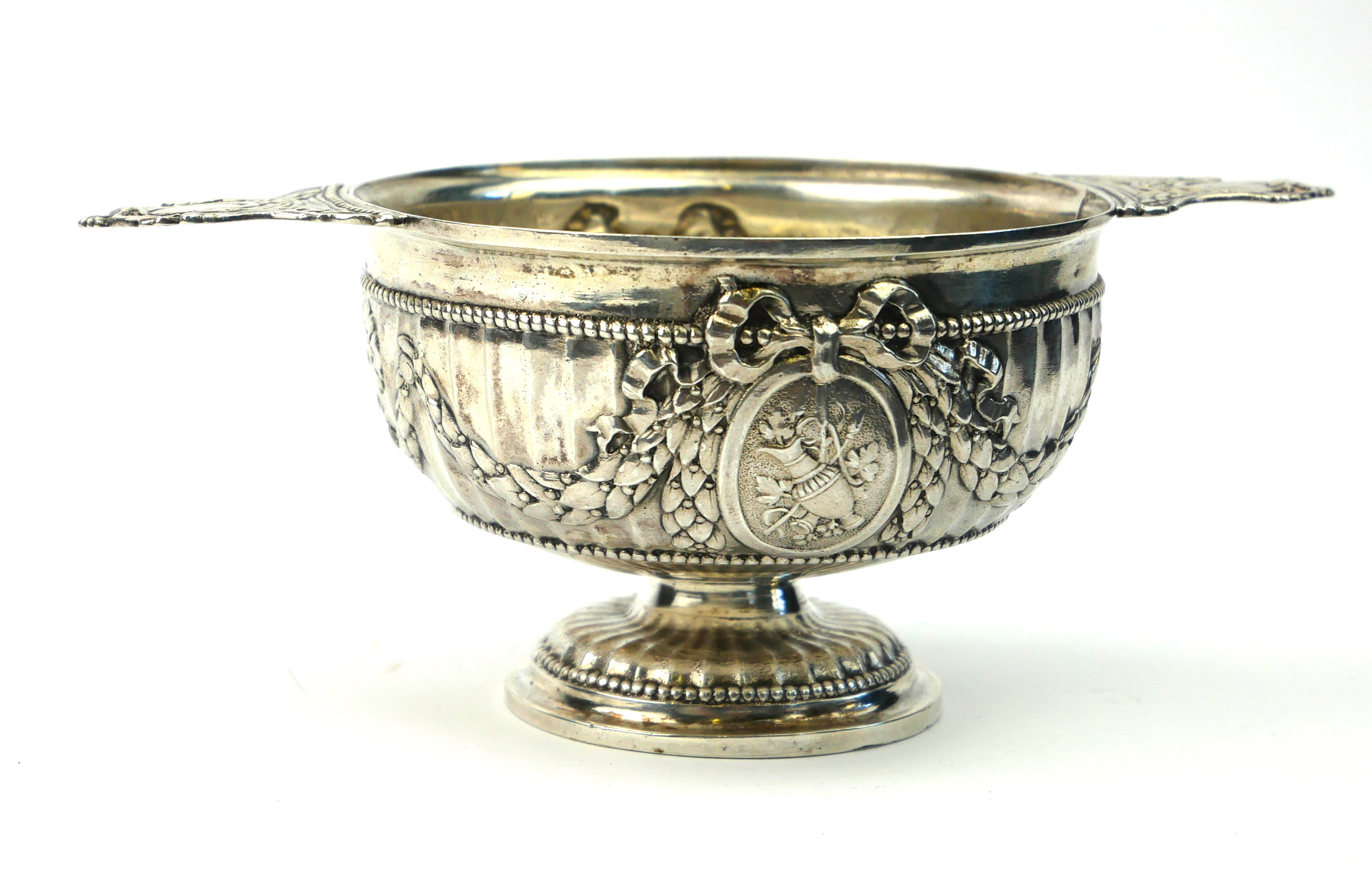 A 19TH CENTURY FRENCH SILVER QUAICH/PORRINGER Having twin handles, the fluted body with embossed