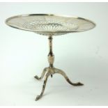 AN EDWARDIAN SILVER MINIATURE TABLE The circular top having pierced decoration, on tripod feet,