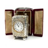 A VICTORIAN SILVER MINIATURE TRAVEL/CARRIAGE CLOCK Having a single carry handle and embossed