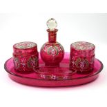 A CRANBERRY GLASS DRESSING TABLE SET Comprising two lidded jars, a scent bottle, pin tray and oval