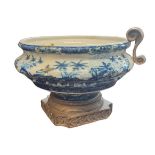 A LARGE BLUE AND WHITE POTTERY AND BRASS SPHERICAL JARDINIÈRE With four scrolled handles,