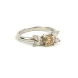 A VINTAGE PLATINUM, CHAMPAGNE DIAMOND AND DIAMOND RING The central round cut stone edged with